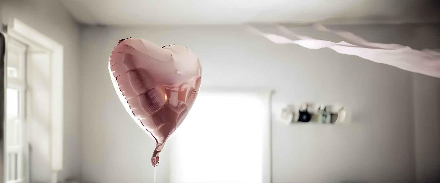 A pink helium, heart shaped balloon