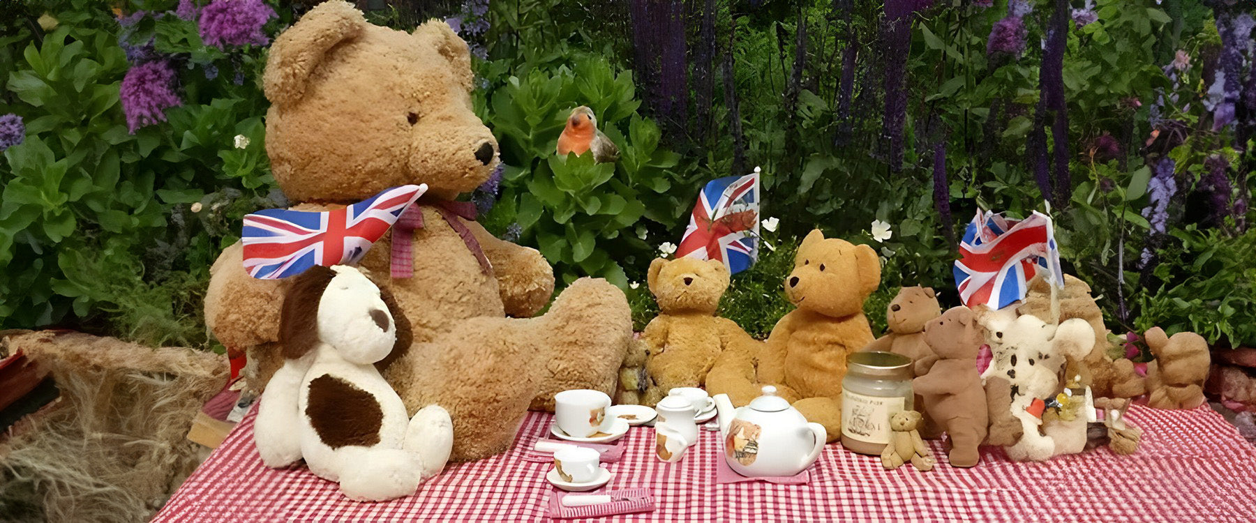  group of teddies having a picnic on a red and white blanket