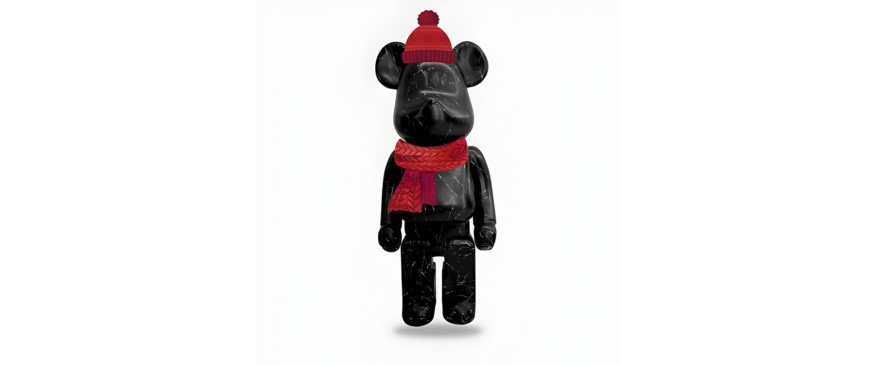 A black giant bear sculpture in a red hat and scarf