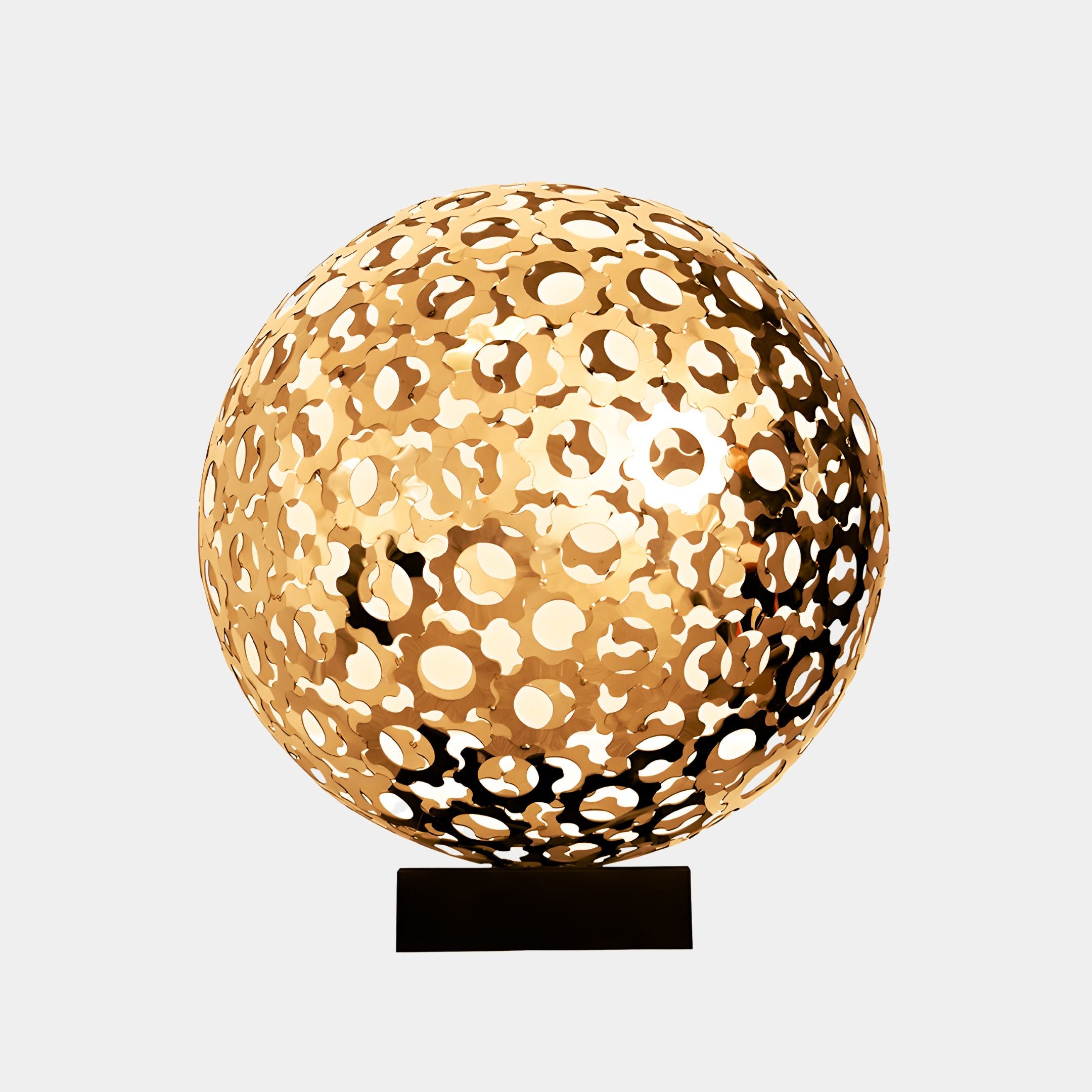 A golden stainless steel abstract sculpture with circular cutouts, creating a striking visual effect, designed for both indoor and outdoor use.