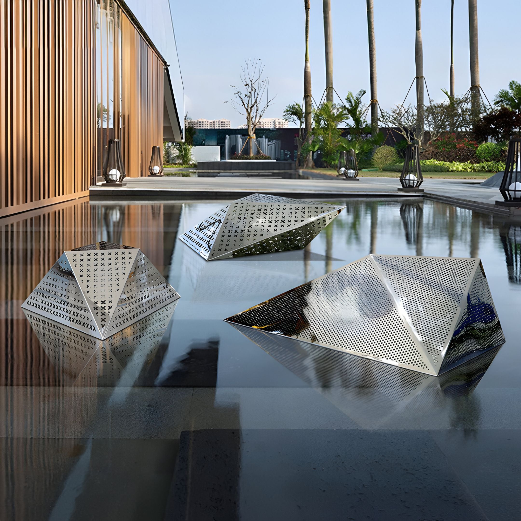 A geometric stainless steel sculpture accentuating a serene outdoor pool area, its perforated pyramid shape casting dynamic light and shadow patterns on the water.