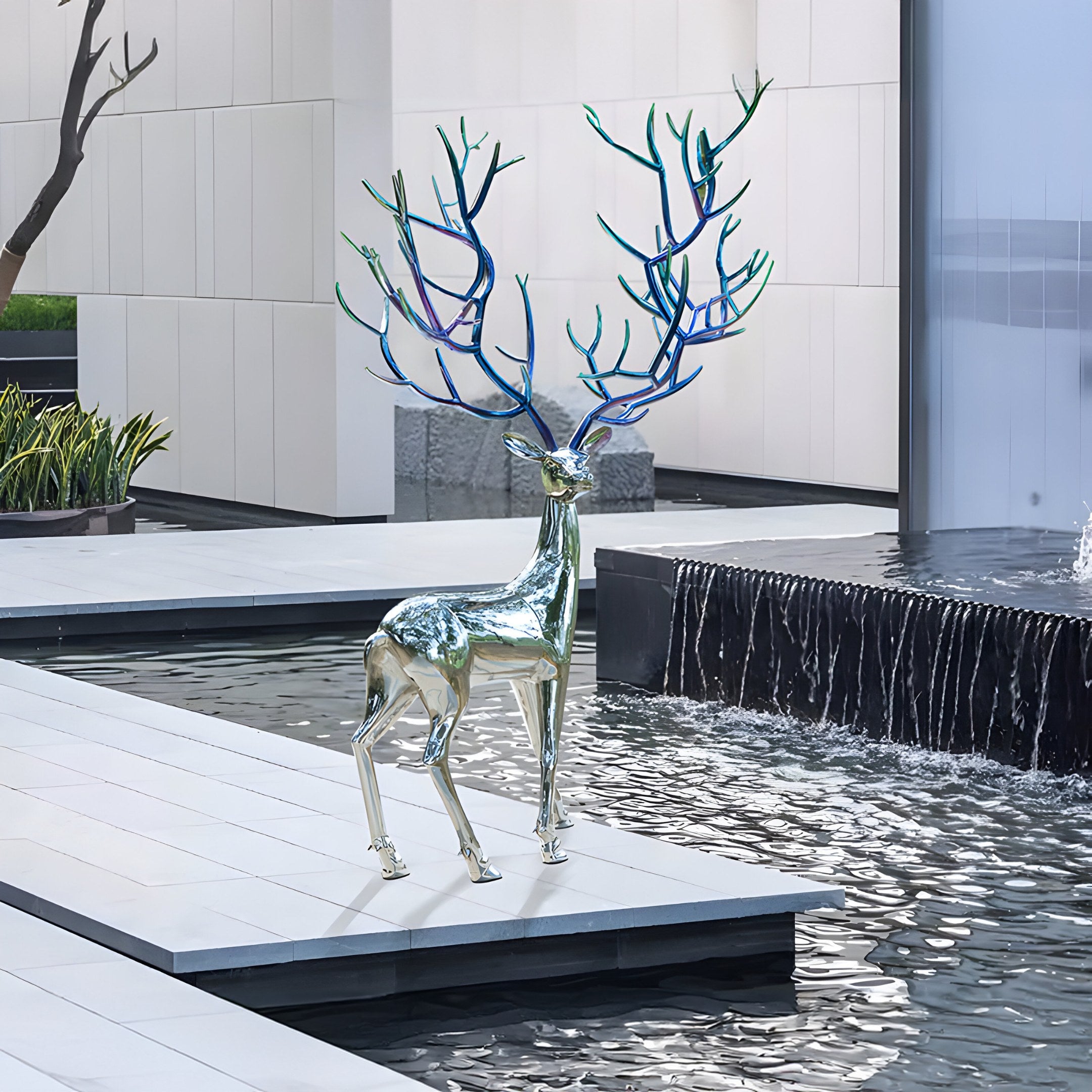 Elegant stainless steel stag with colorful antlers beside a modern water feature, enhancing the landscape with reflective surfaces